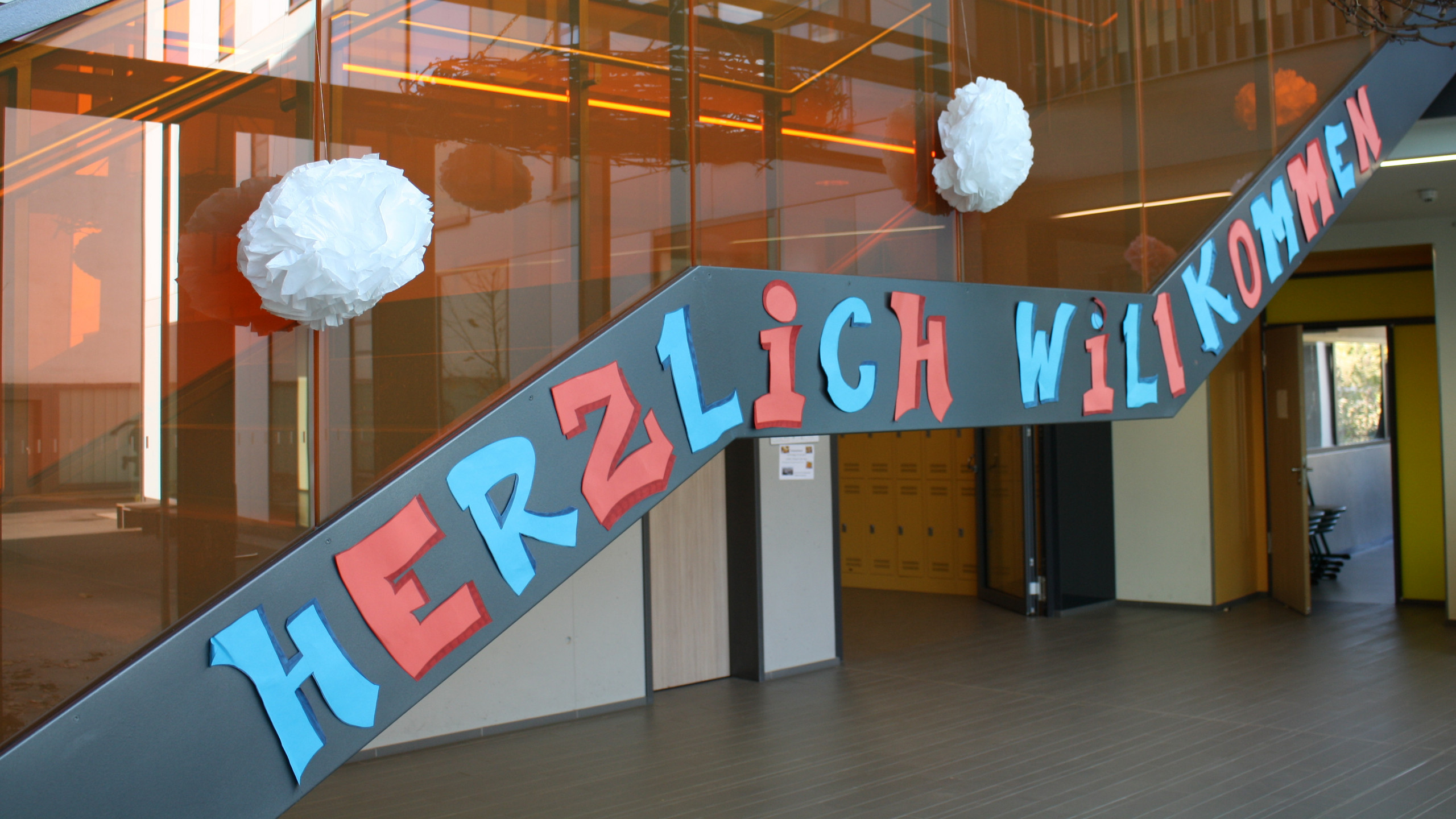 Ein Bild vom Treppenhaus der Schule mit einem Willkommens-Banner